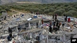 Socorristas y residentes buscan entre los escombros de los edificios derrumbados por un temblor en la ciudad de Harem, cerca de la frontera turca, provincia de Idlib, Siria, el lunes 6 de febrero de 2023. (Foto AP/Ghaith Alsayed)