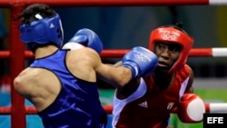 Archivo - El cubano Yordenis Ugas, (rojo) en acción frente al rumano Georgian Popescu durante el combate de boxeo de cuartos de final de los Juegos Olímpicos de Pekín 2008. 