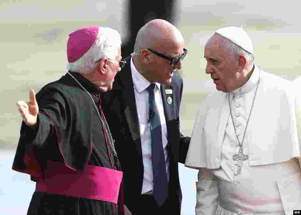 El papa Francisco (d) y el arzobispo Dionisio Guillermo García hablan a su llegada al aeropuerto Antonio Maceo, en Santiago de Cuba.